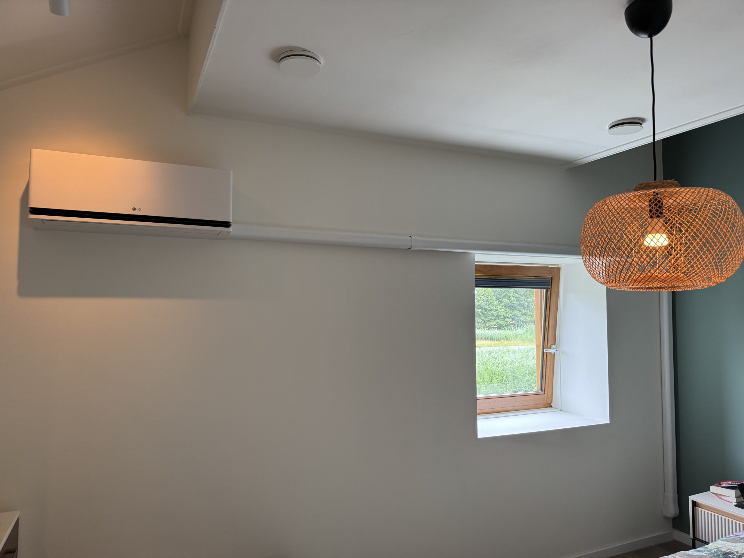 LG airco-binnenunit in een slaapkamer met strakke leidingafwerking